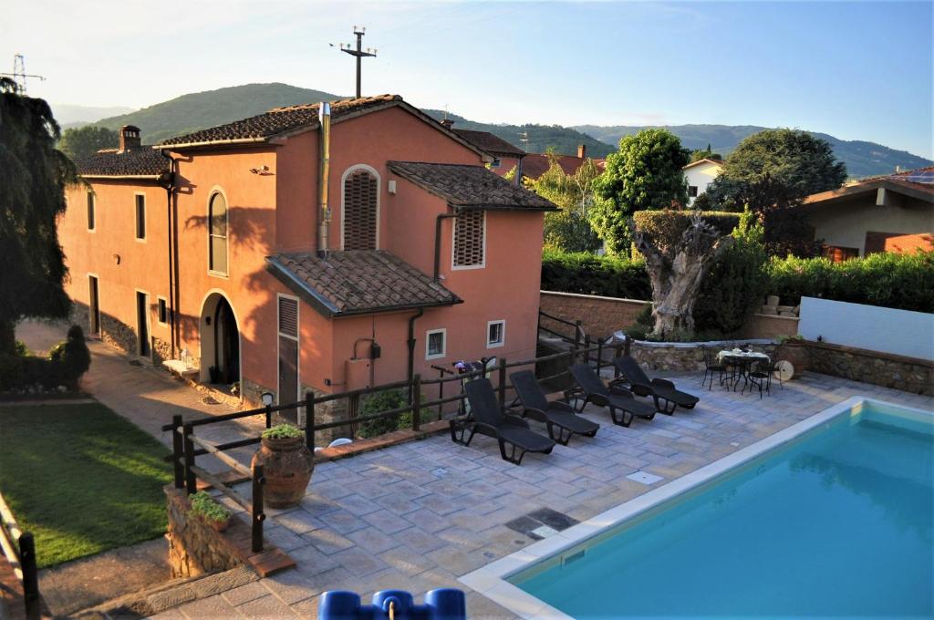 a villa with a swimming pool in front of a house at Bella Toscana Relax in Monsummano Terme