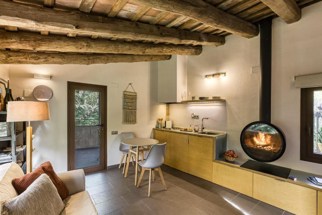 a kitchen with a living room with a fireplace at La Pallissa - Can Bonet in Sant Martí Vell