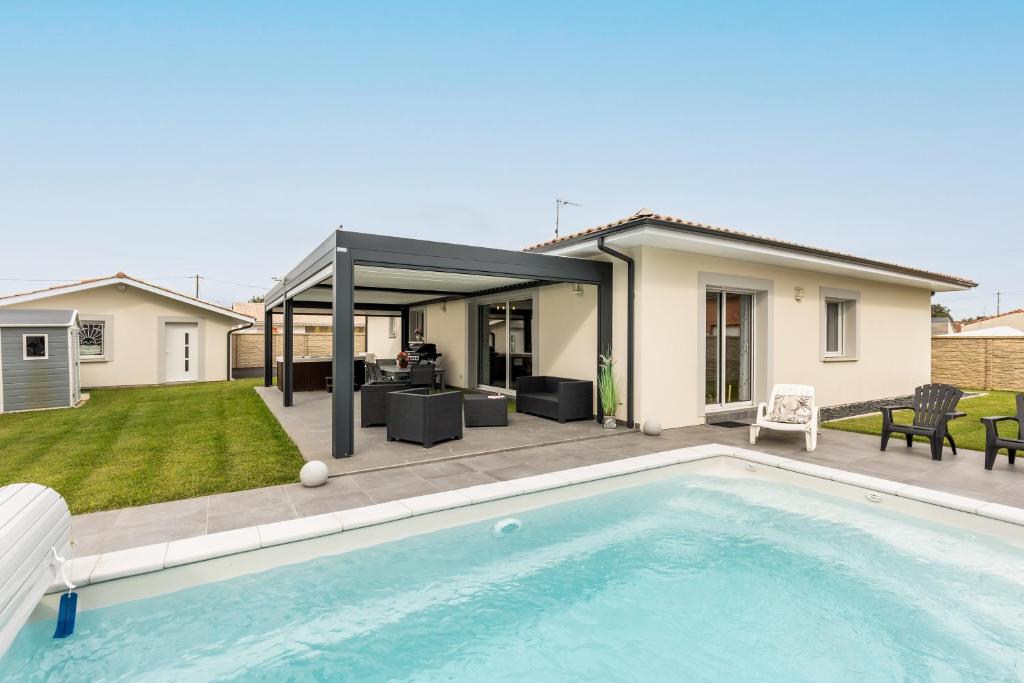 a backyard with a swimming pool and a house at Villa bassin d´archachon in Arès