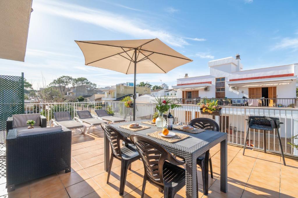 a patio with a table and chairs and an umbrella at Fantastic in Can Picafort