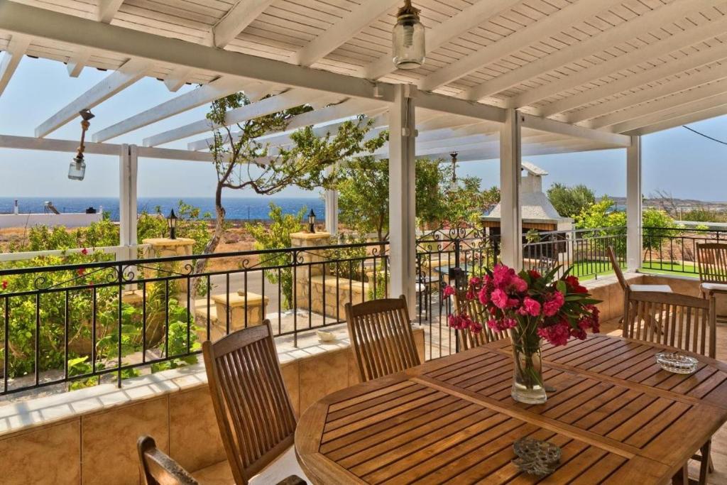 a wooden table with a vase of flowers on a porch at Villa Ntora in Afiartis