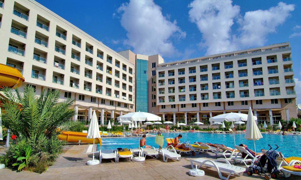 a hotel with a swimming pool with people sitting in chairs at Miarosa Konakli Garden in Konaklı