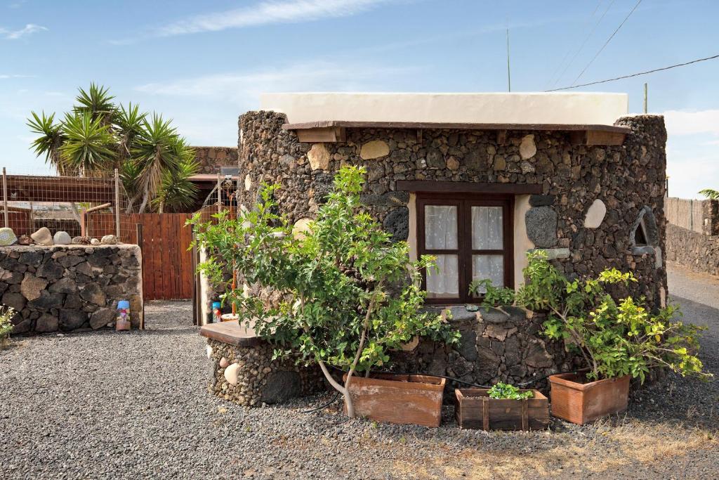 a stone house with plants in front of it at Yukalele 2 in Lajares
