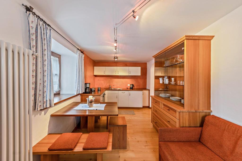 a kitchen with a wooden table and a dining room at Florerhof Ferienwohnung Rose in Vols am Schlern