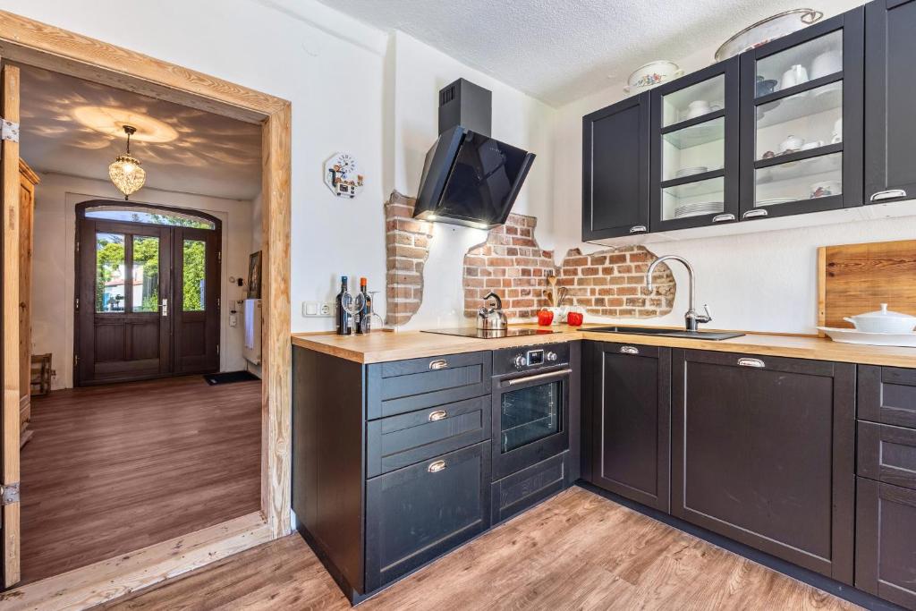 a kitchen with black cabinets and a tv on the wall at Kleines Glück in Seedorf