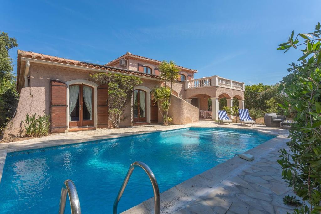a villa with a swimming pool in front of a house at Villa Elisabeth in Fréjus