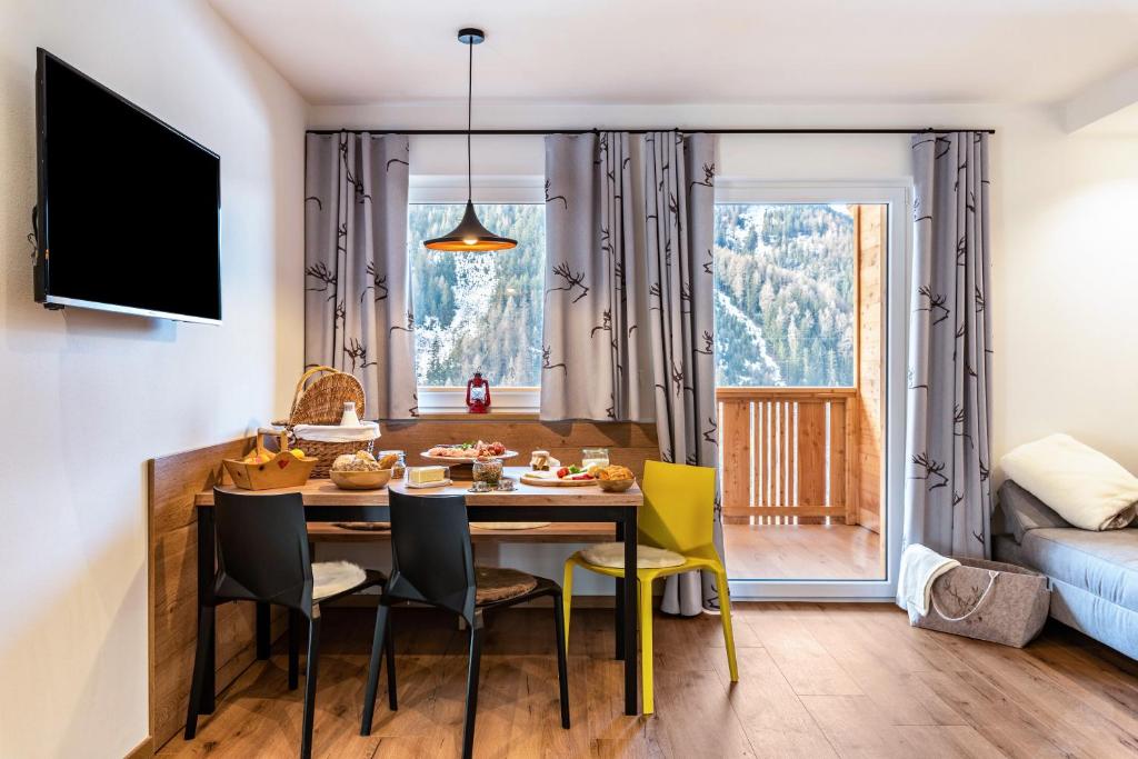a kitchen and dining room with a table and chairs at Balbeinhof Apt Hirsch in Luson