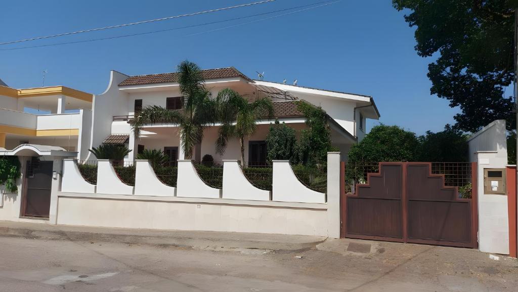 a white fence in front of a house at Dall'alba al Tramonto in Alezio
