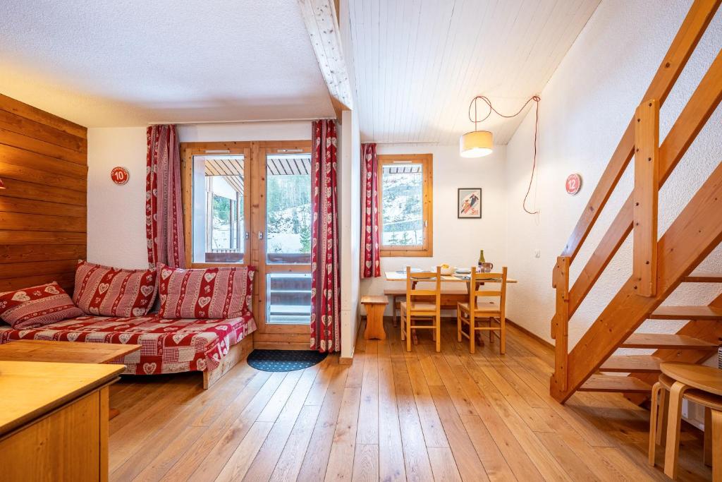 a living room with a couch and a table at Lauziere dessus 50 in Valmorel