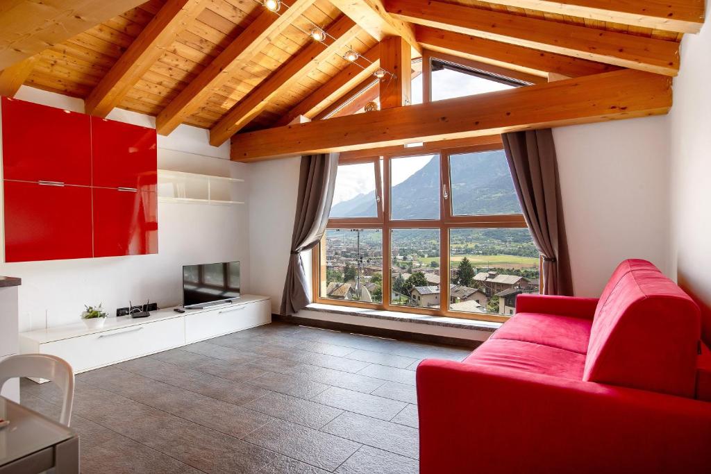 a living room with a red couch and a large window at La Maison De Carletto in Sarre