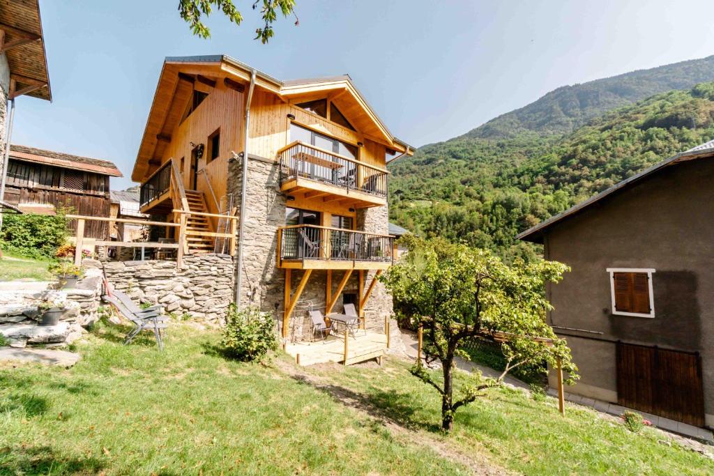 a house on a hill with mountains in the background at Chalet Agréable 3 étoiles app 4 in Courchevel