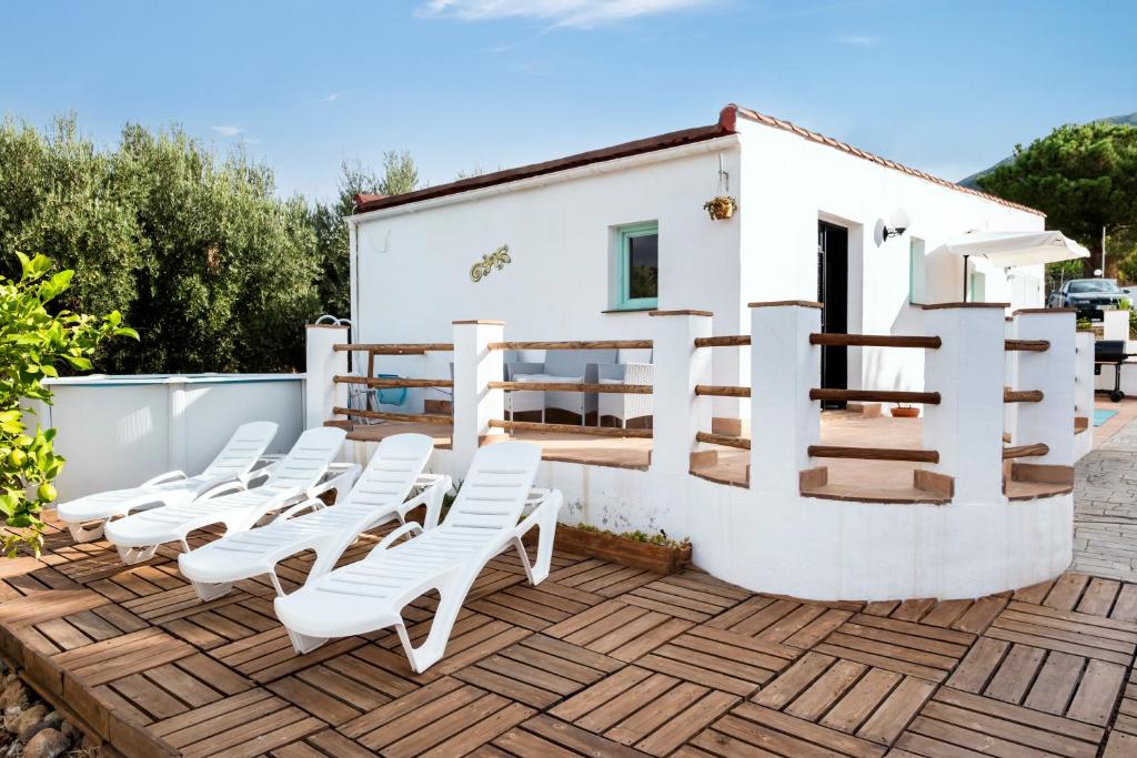 a group of white chairs sitting on a wooden deck at La Casita del Limoncito in Alcaucín