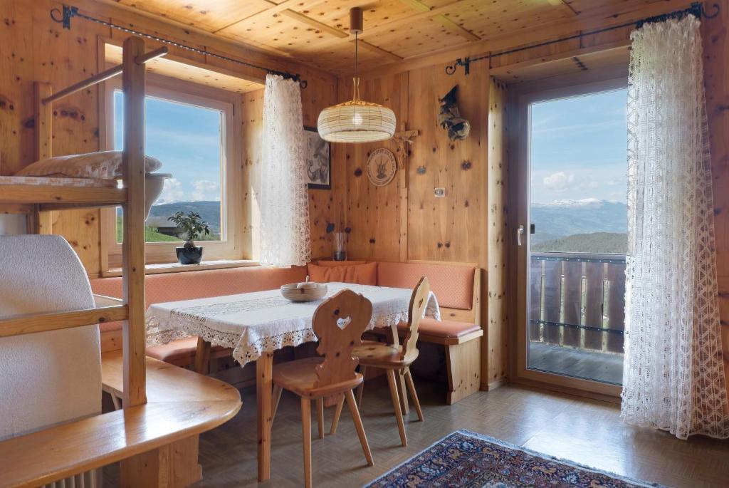 a dining room with a table and a balcony at Apartment Rosengartenblick in Steinegg