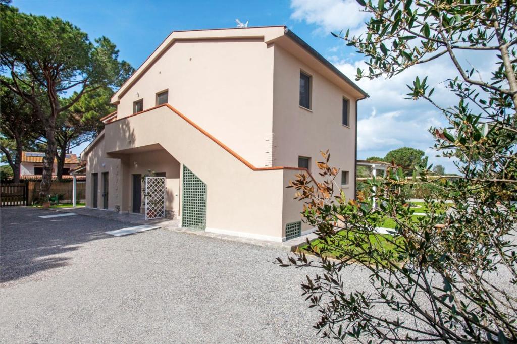 a large white house with a driveway at Casale Lorenzo Appartamenti in Orbetello