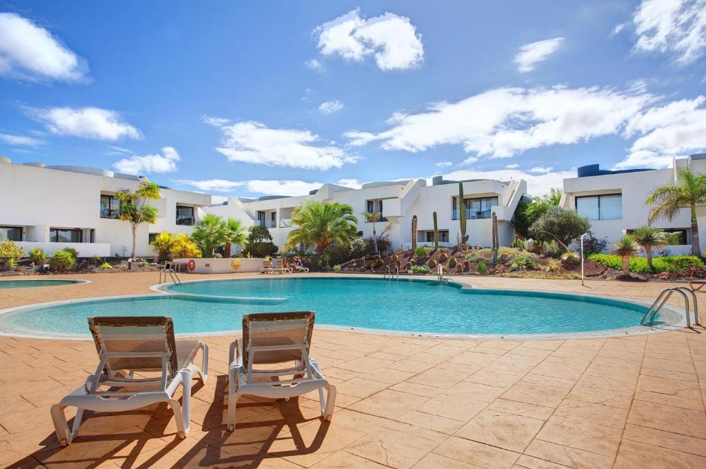 two chairs sitting in front of a swimming pool at The Garden Secret in Villaverde
