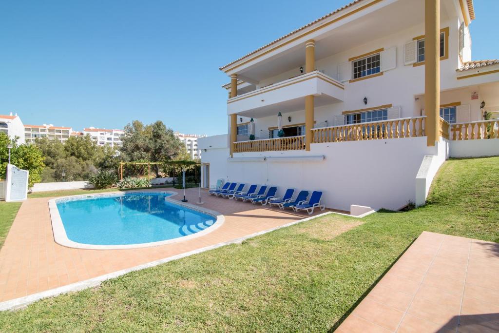 a villa with a swimming pool and a house at Villa do Lago in Albufeira
