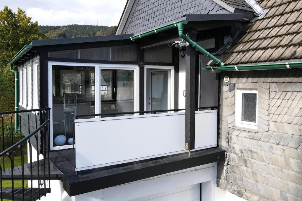 a house with a white door and a balcony at Ferienwohnung Blum in Schmallenberg