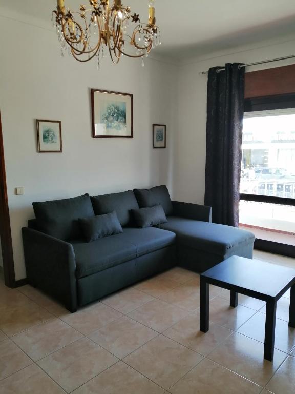 a living room with a blue couch and a table at Casa Guerreiro in Branqueira