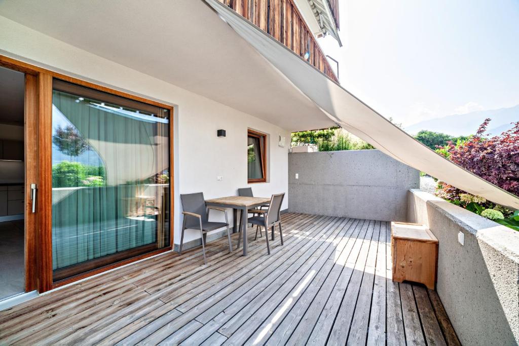 a wooden deck with a table and chairs on a house at Langstein Wohnung Golden in Coldrano
