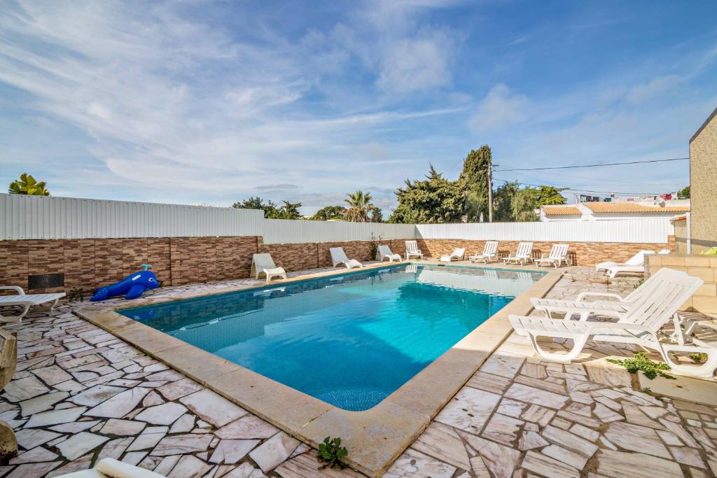 a swimming pool with lounge chairs and a swimming pool at T2 Anastácio com vista Jardim in Olhos de Água