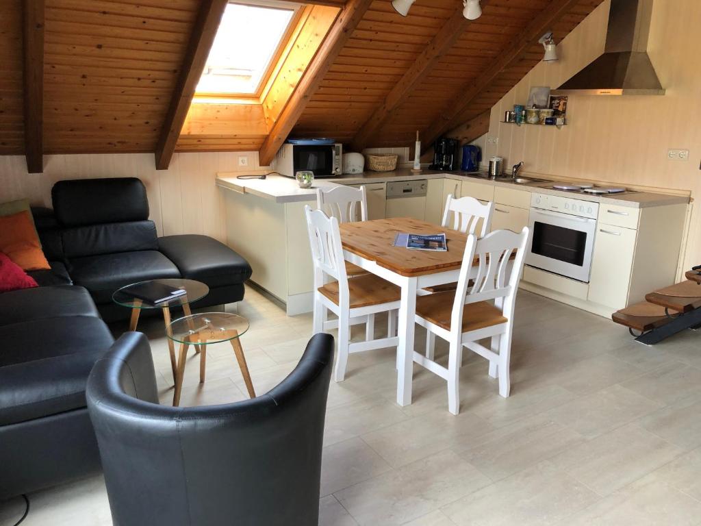 a kitchen and living room with a table and chairs at Ferienwohnung Borkum in Burhave