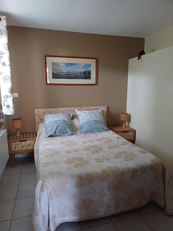 a bedroom with a large bed with blue pillows at Gite paysan lecarpentier in Fontenay