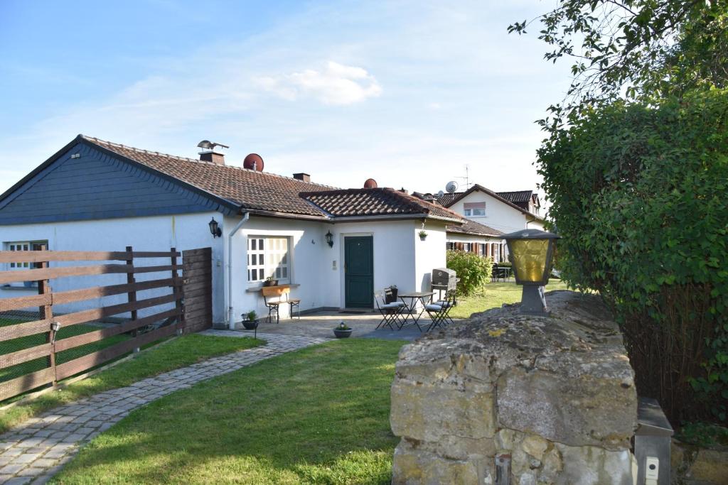 a white house with a fence and a yard at Casa Schrader in Kaltenholzhausen