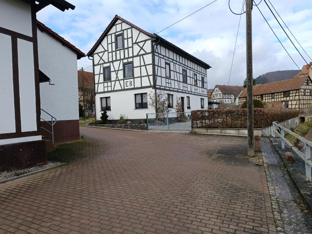 a white and black building on a brick road at Ferienwohnung Papperitz in Heiligen