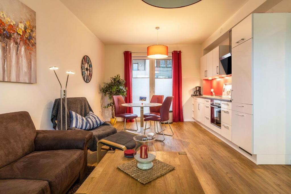 a living room with a couch and a table at Ferienwohnung Büsumperle weiß in Büsum