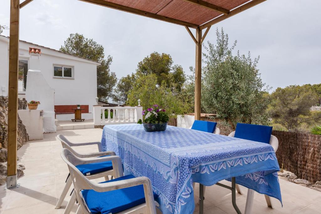 a blue table and chairs on a patio at Casita Palmeras in Canyelles