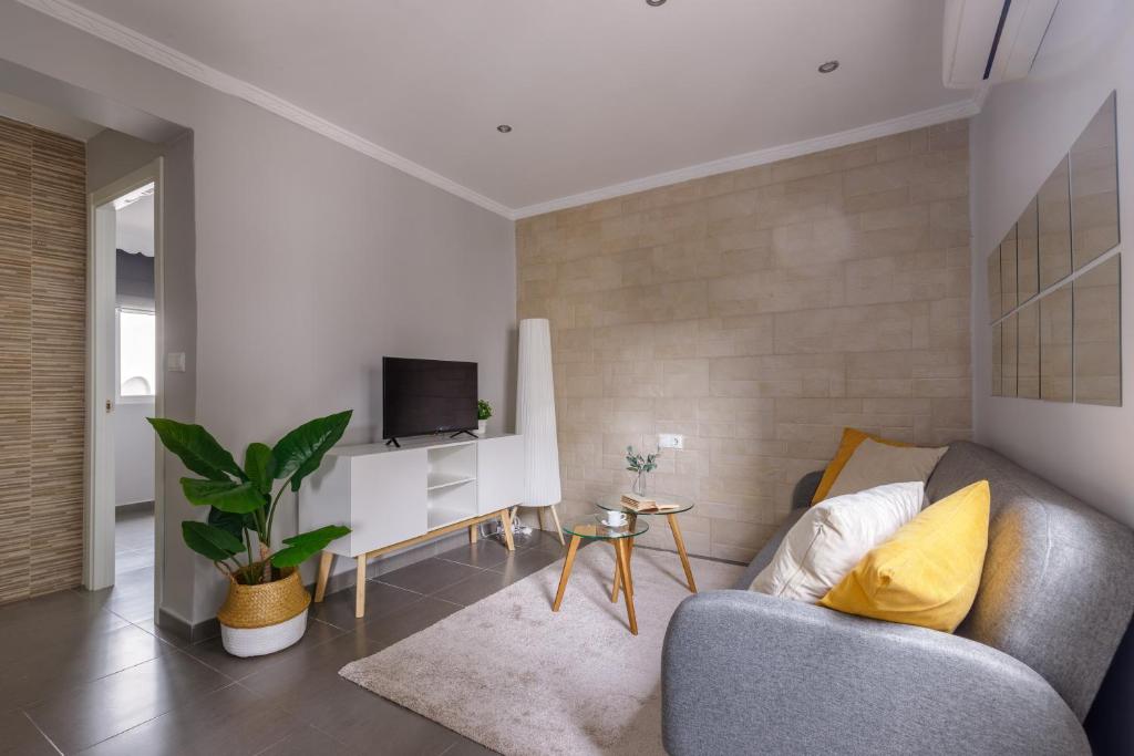 a living room with a couch and a tv at Málaga Dream Apartment in Málaga