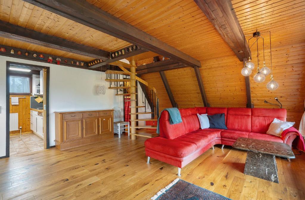 a red couch in a living room with wooden ceilings at Ferienhaus Bussardnest in Tennenbronn