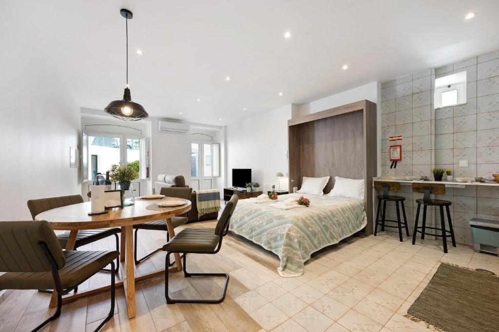 a bedroom with a bed and a table and a kitchen at Villa Xique 11 in Monchique