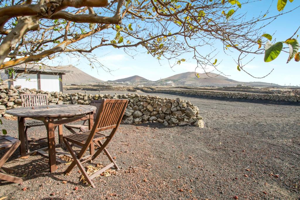 a table and chair sitting next to a stone wall at Estudio Pu in La Vegueta