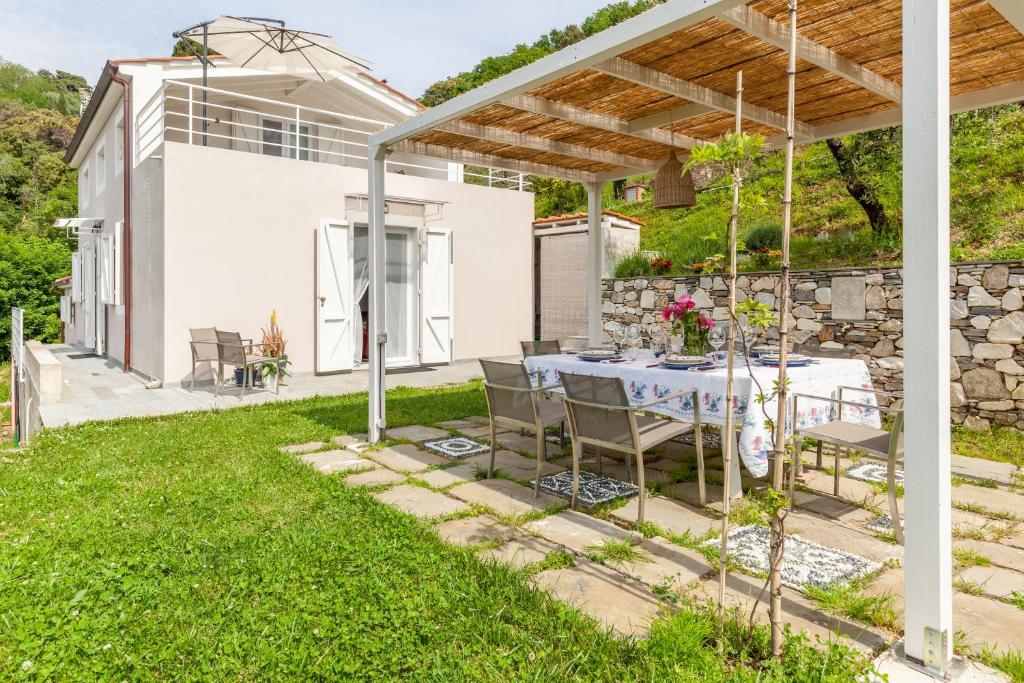 a patio with a table and chairs under a pergola at Casa Lu in Massarosa