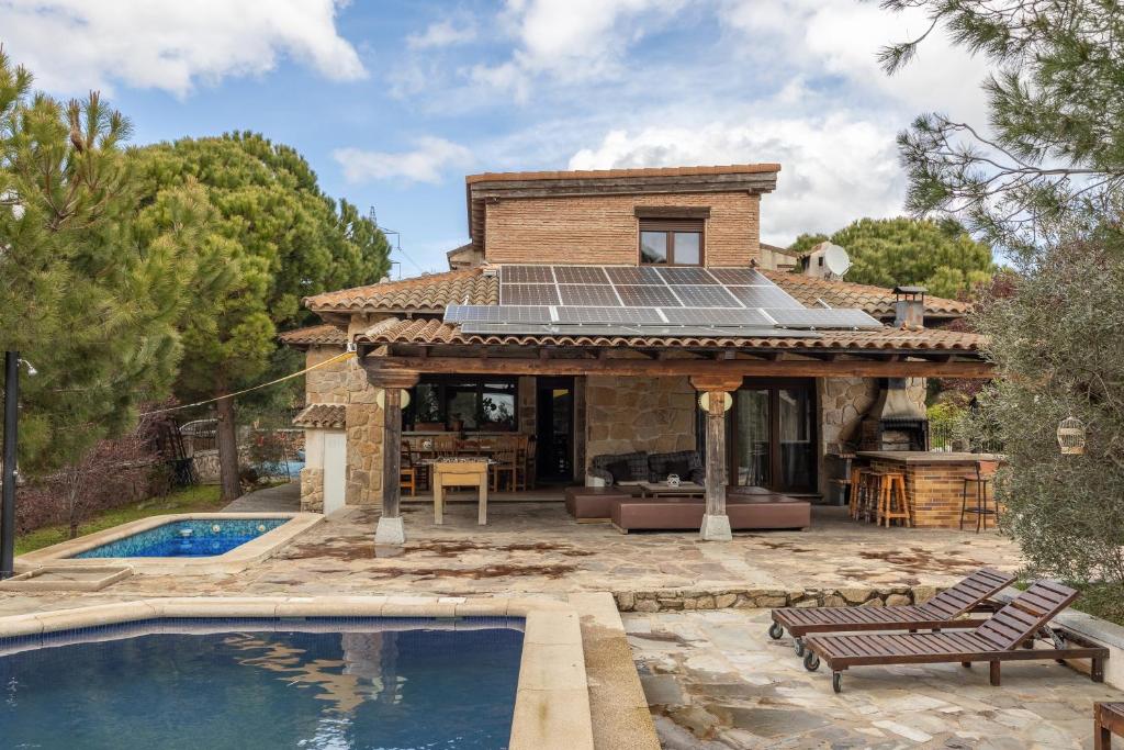 a house with a solar roof and a swimming pool at El Berrueco in El Berrueco