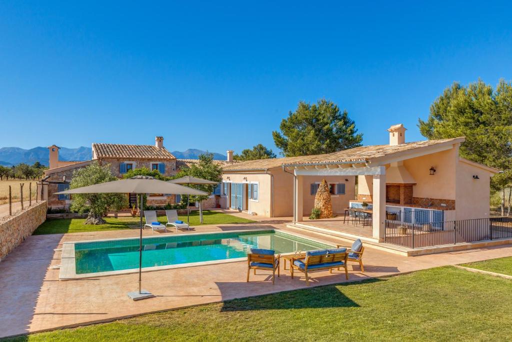 a villa with a swimming pool and a house at Sa Vinya Jove in Biniali