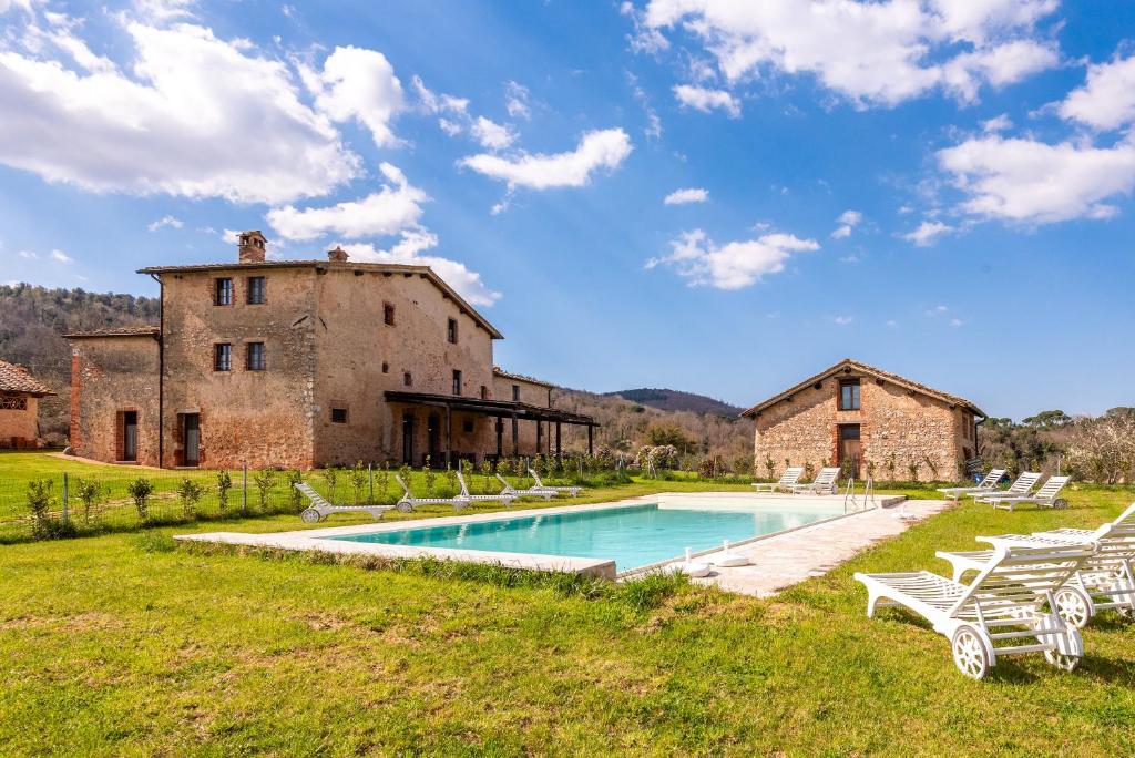 an estate with a swimming pool in front of a building at Agriturismo la Taverna Di Celsa in Sovicille