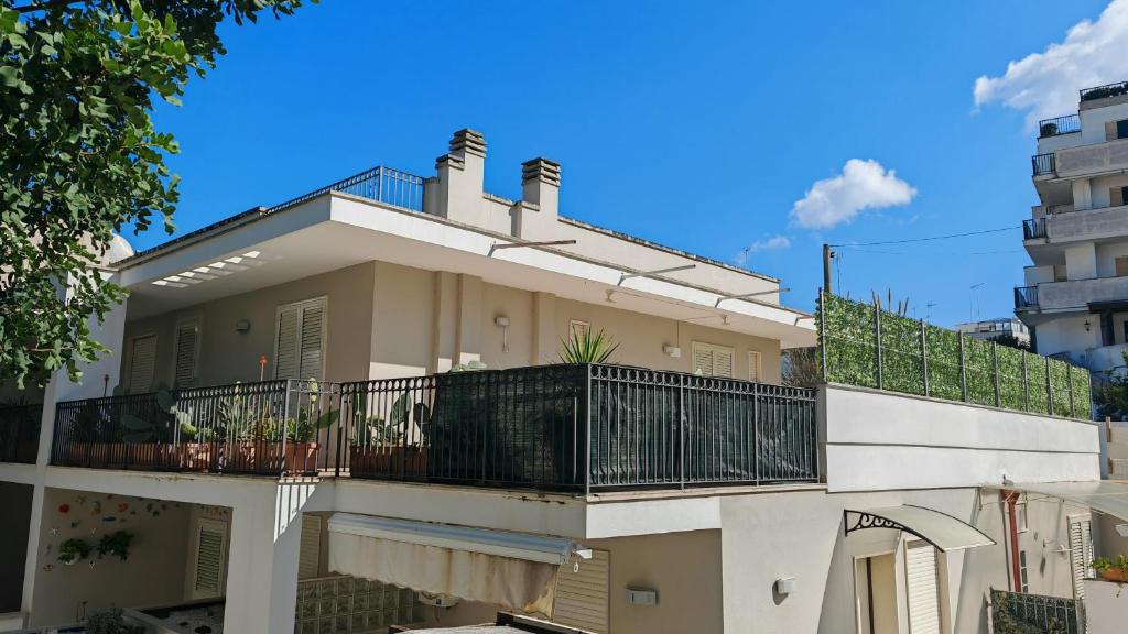 a building with a balcony with a fence at Andromeda's Rooms in Otranto