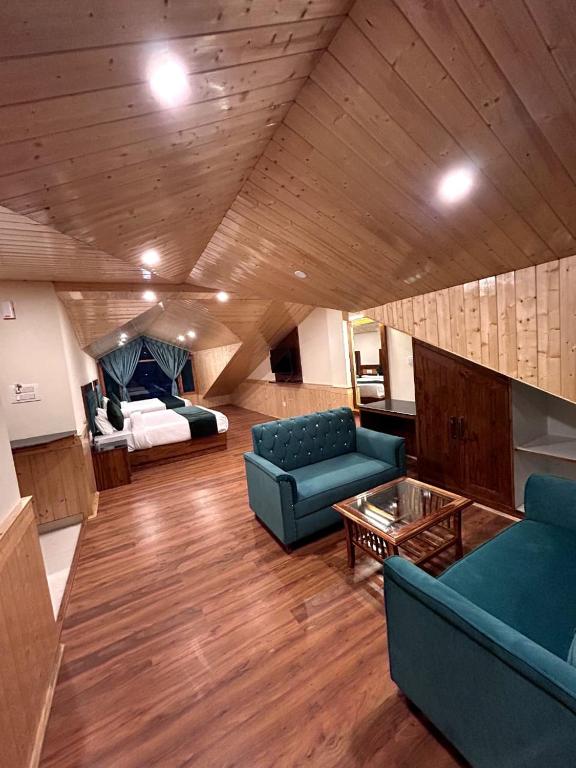 a living room with blue couches and a bed at Hidden Heaven Waterfall view in Manāli