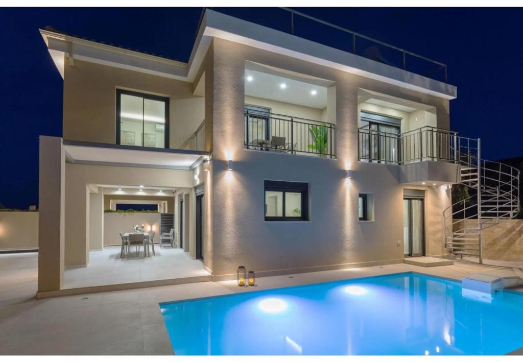 a large house with a swimming pool in front of it at Villa Zografia in Alikanas
