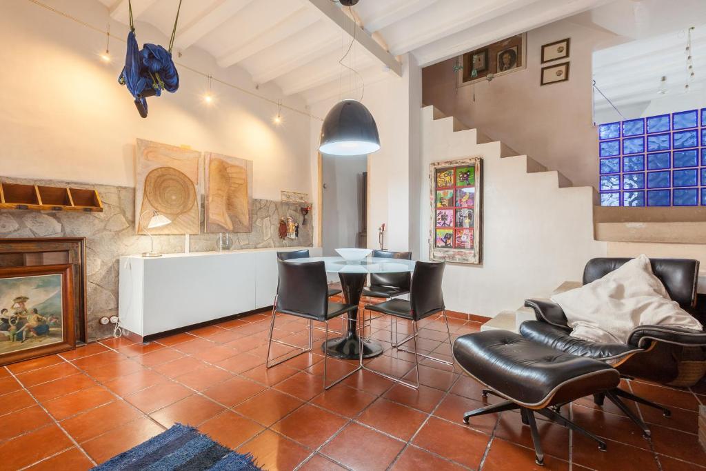 a living room with a table and chairs and a staircase at Maresme Natura in Sant Iscle de Vallalta