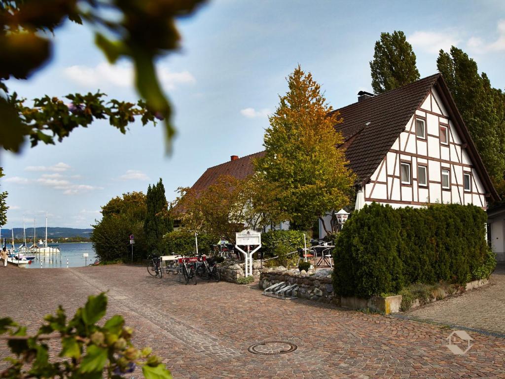 a large white building next to a body of water at Gästehaus Perlmuschel in Iznang