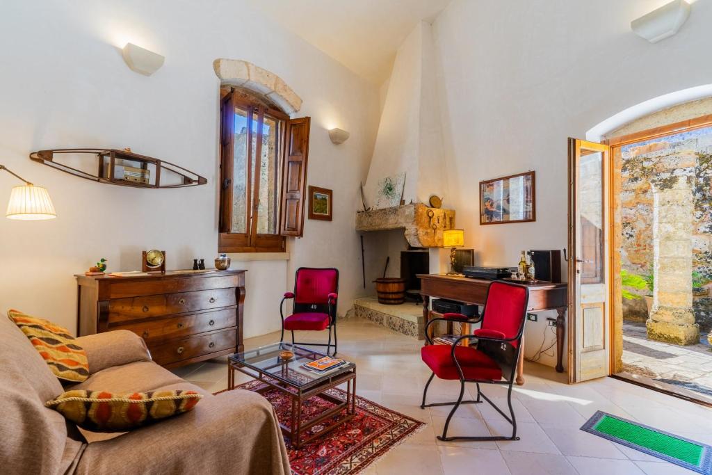 a living room with a couch and red chairs at Antica corte dell'800 in Castrignano del Capo