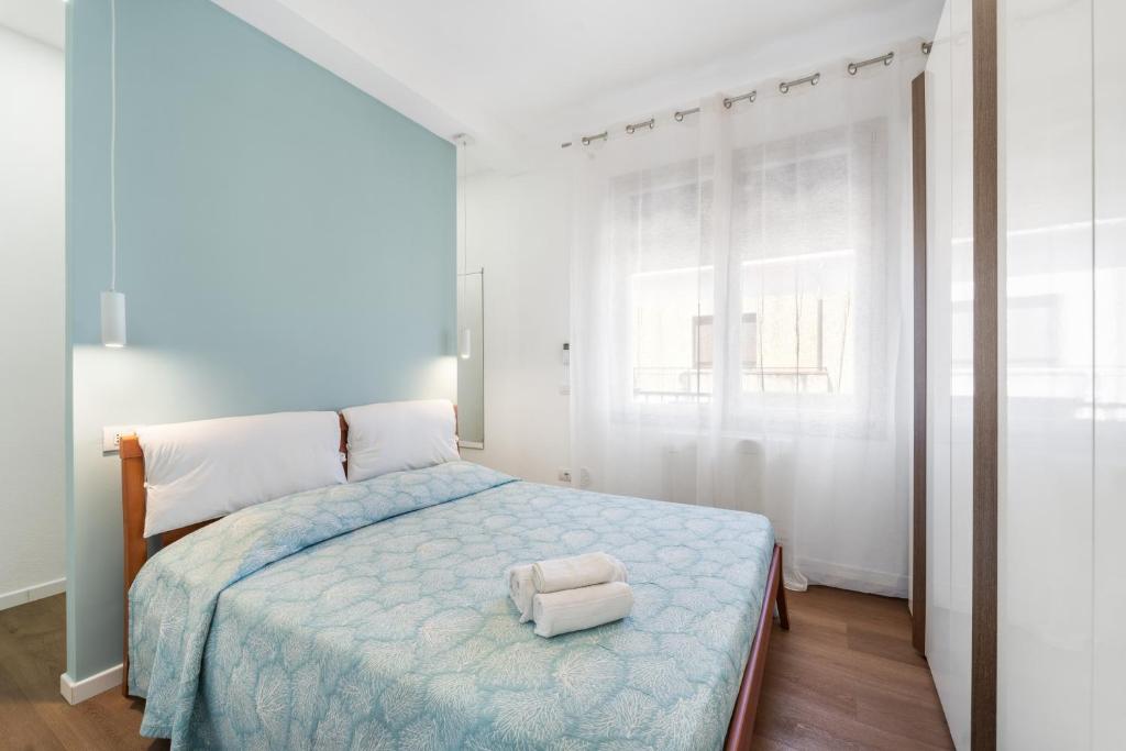 a bedroom with a bed with a blue comforter at 4 Seasons Apartment in Guspini