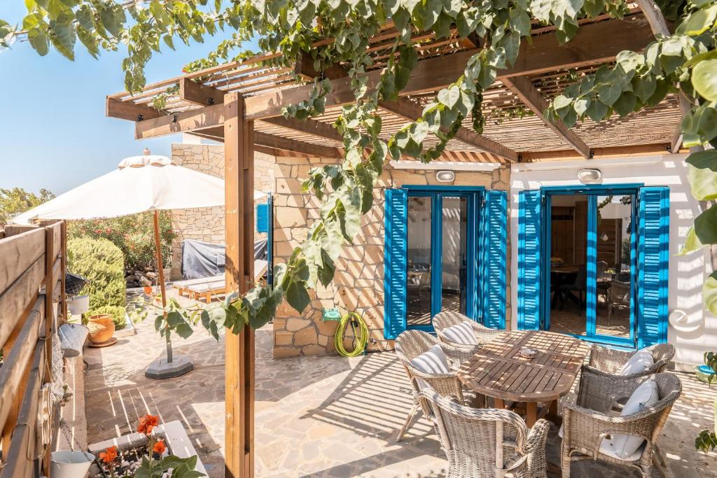 a patio with a table and chairs and an umbrella at Villa Kalliope in Gennadi