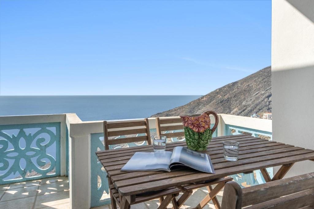 a wooden table on a balcony with a view of the ocean at Olympos Blue in Karpathos