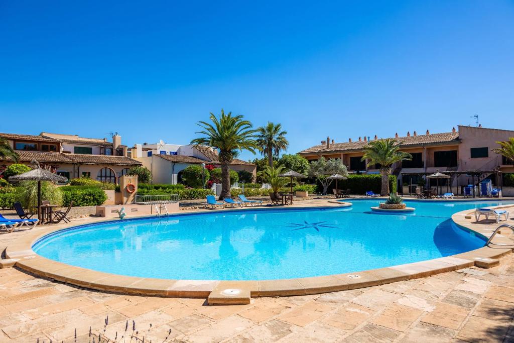 a large swimming pool with palm trees and buildings at Casa Arts 50 in Campos