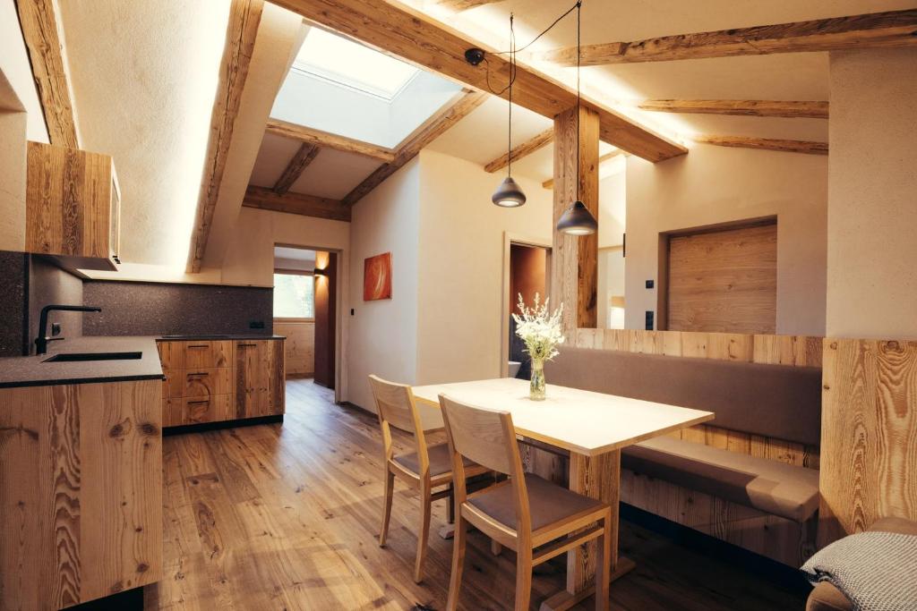 a kitchen with a table and chairs in a room at Obertimpflerhof Wohnung Lola in Verano