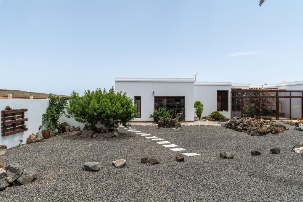 a courtyard with rocks and a white building at Guenia ll in El Mojón